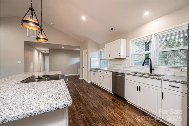 a large kitchen with kitchen island a sink stainless steel appliances and cabinets