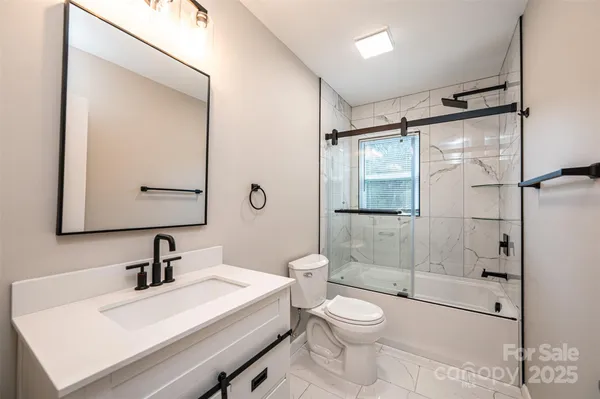 a bathroom with a sink toilet a mirror and shower