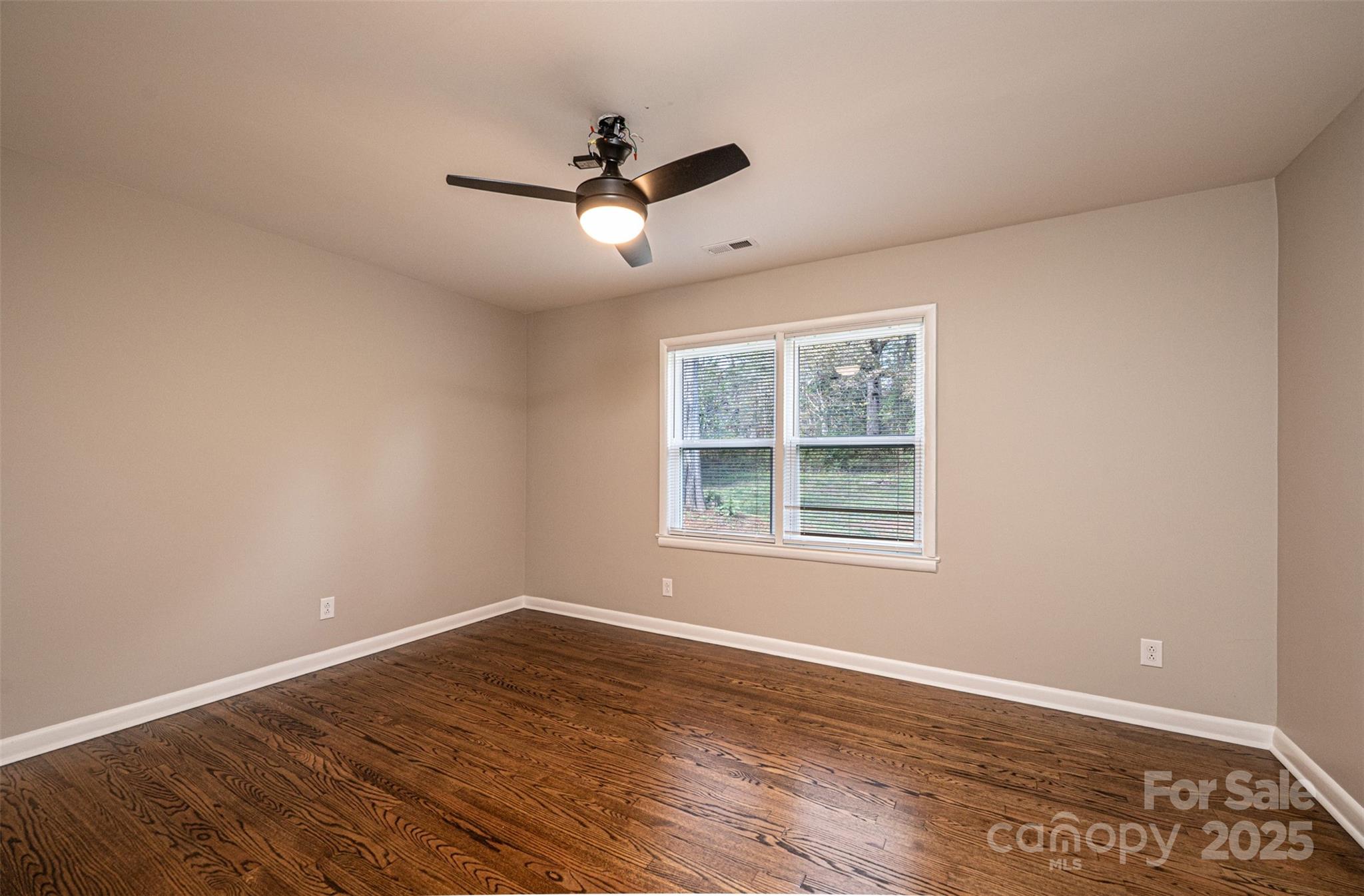908 13th Street Northwest Conover, NC 28613 - Photo 19 of 25 an empty room with wooden floor ceiling fan and windows