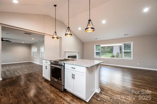 a kitchen with stove and wooden floor