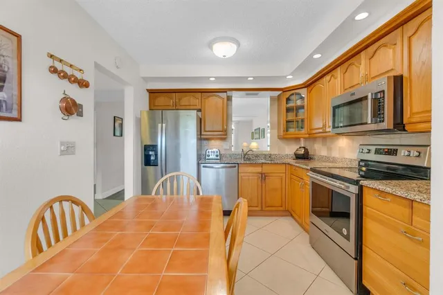 a kitchen with stainless steel appliances granite countertop a stove a sink and a microwave