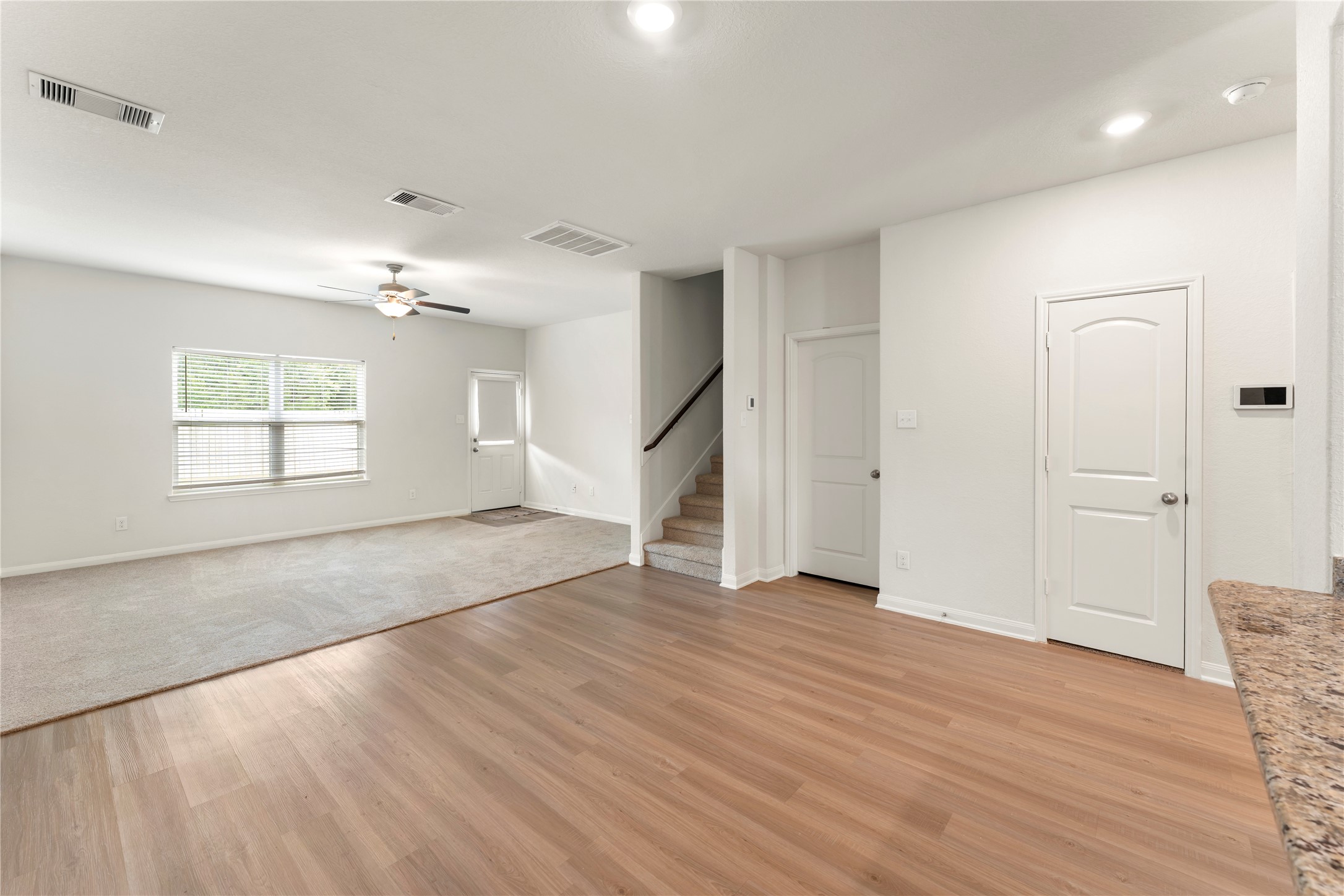 9702 Opal Gates Drive Rosharon, TX 77583 - Photo 12 of 43 an empty room with wooden floor cabinet and windows