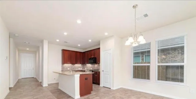a kitchen with stainless steel appliances kitchen island granite countertop a stove and a sink
