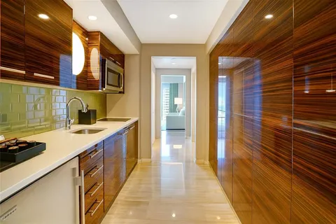 a view of a hallway with wooden floor and a living room