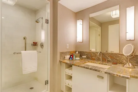 a bathroom with a granite countertop bathtub sink and toilet