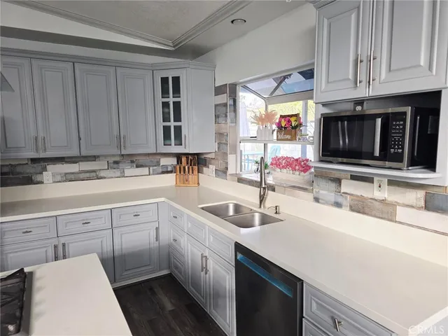 a kitchen with granite countertop a sink stainless steel appliances and cabinets