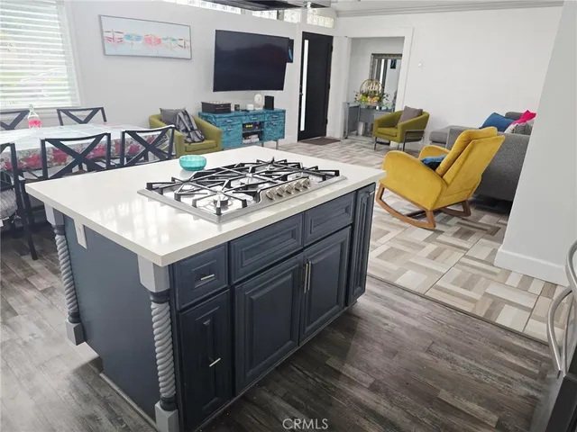 a living room with furniture a flat screen tv and a stove