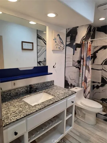 a bathroom with a granite countertop sink and a mirror