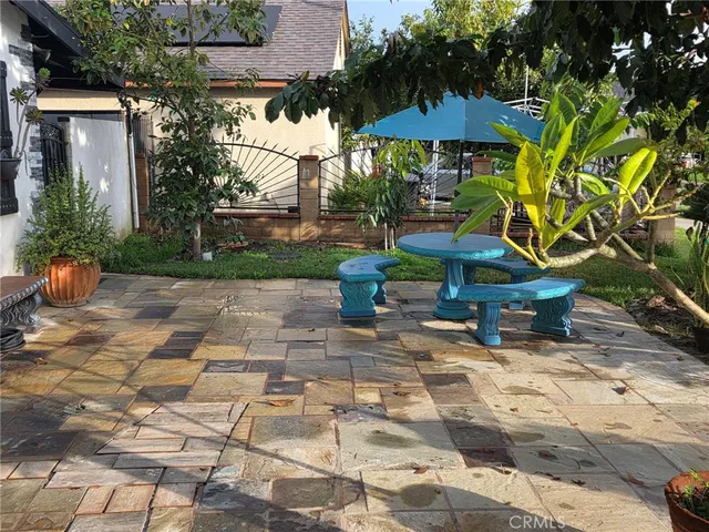 a view of a chairs and table under an umbrella in backyard