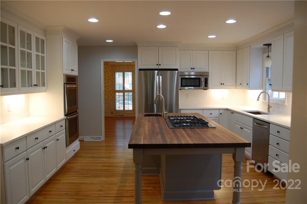 3101 Colony Road Charlotte, NC 28211 - Photo 5 of 26 a kitchen with kitchen island granite countertop a stove refrigerator and cabinets