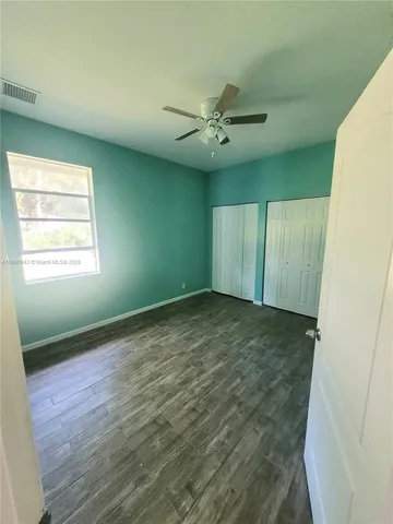 a view of empty room with window and ceiling fan