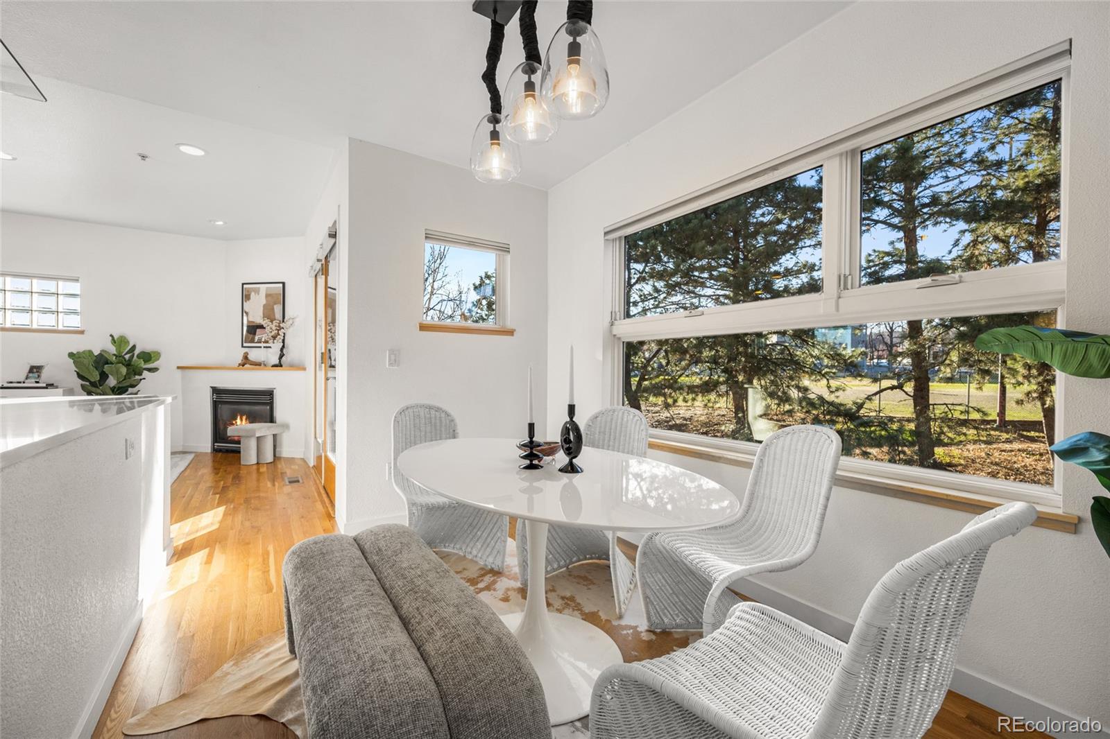 a dining room with furniture a large window and wooden floor
