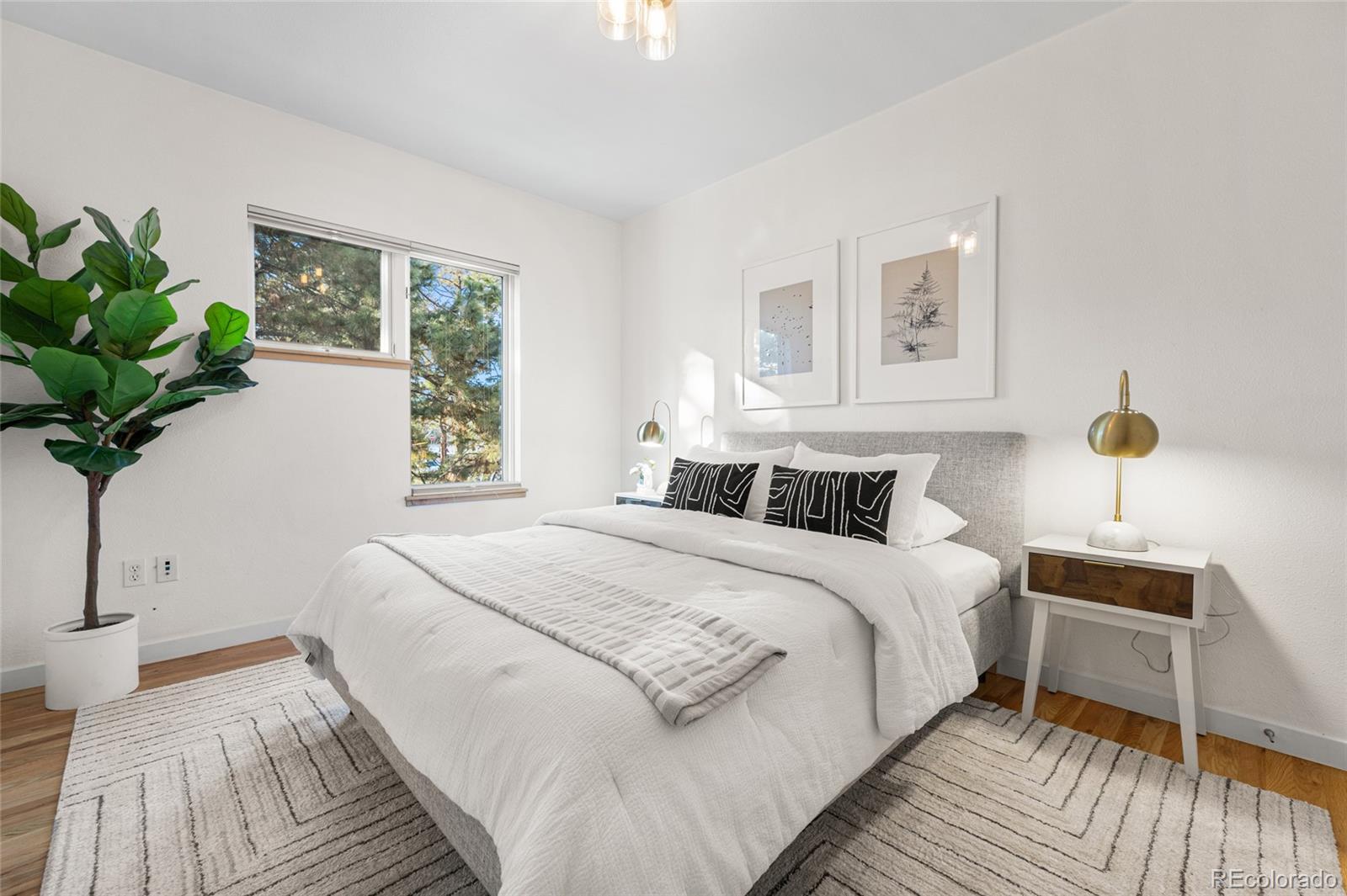 1675 Boulder Street Denver, CO 80211 - Photo 16 of 39 a bedroom with a large bed and a potted plant