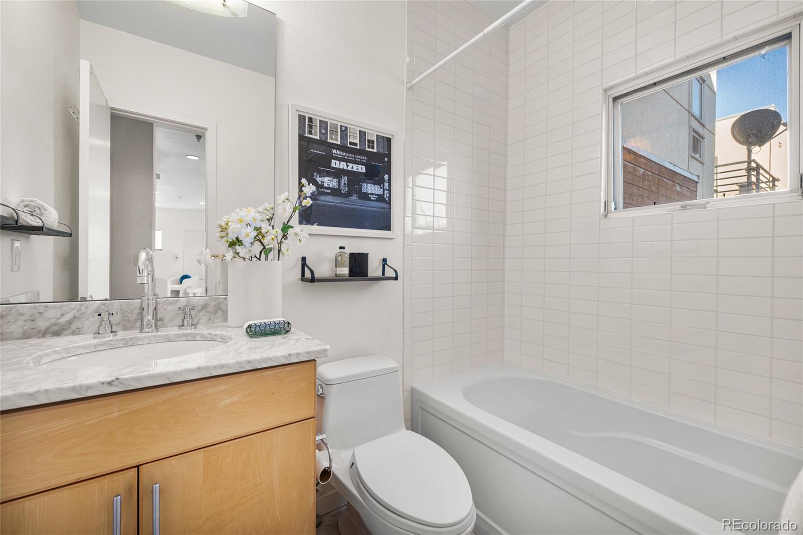 1675 Boulder Street Denver, CO 80211 - Photo 17 of 39 a bathroom with a granite countertop sink toilet mirror and bathtub