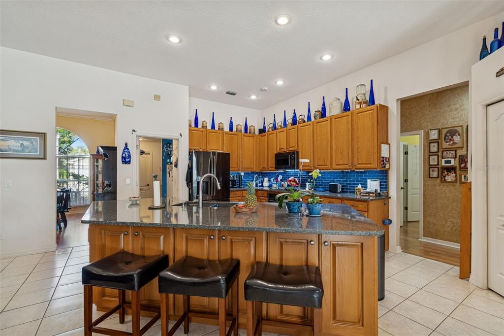 928 Oakview Road Tarpon Springs, FL 34689 - Photo 11 of 75 a kitchen with stainless steel appliances kitchen island granite countertop a table and chairs