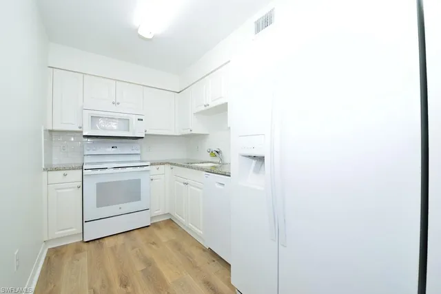 a kitchen with cabinets and white appliances