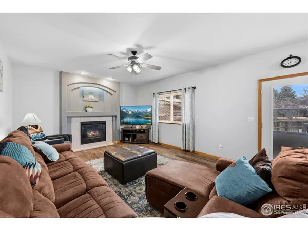 a living room with furniture a fireplace and a large window