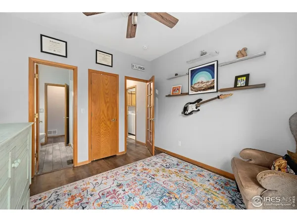 a view of a bedroom with a bed and wooden floor