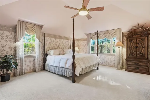 a spacious bedroom with a bed chandelier and a window