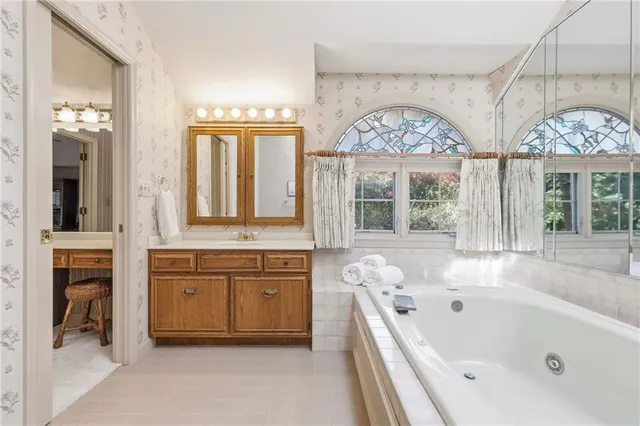 a bathroom with a tub sink and mirror