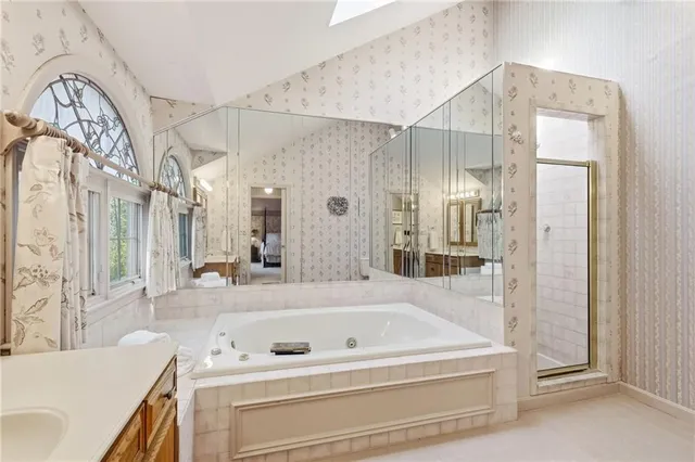 a bathroom with a tub a sink and a mirror