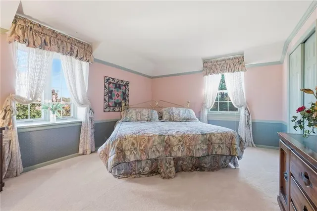 a bedroom with a large bed and a potted plant