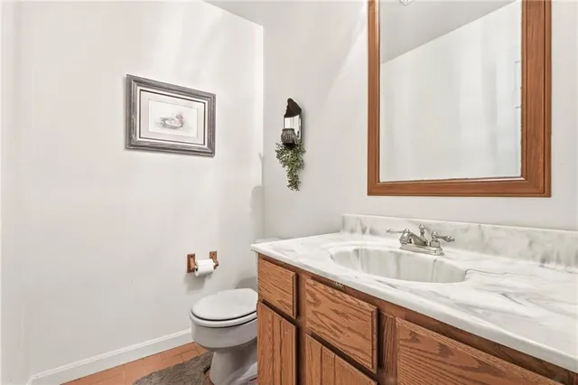 a bathroom with a granite countertop sink and a toilet
