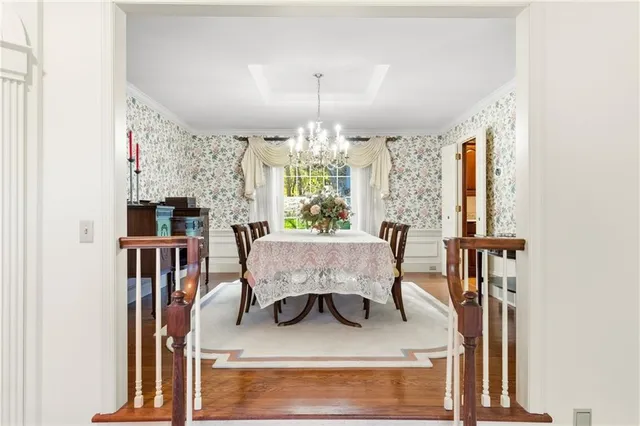 a living room with furniture a chandelier and a dining table