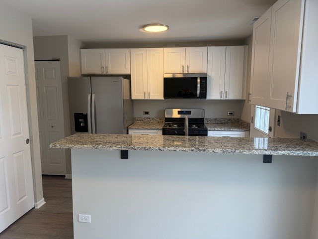 588 Nantucket Way, Unit 2 Island Lake, IL 60042 - Photo 4 of 29 a kitchen with stainless steel appliances a stove refrigerator sink and microwave
