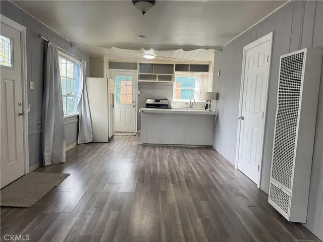 a kitchen with stainless steel appliances wooden floors and large window