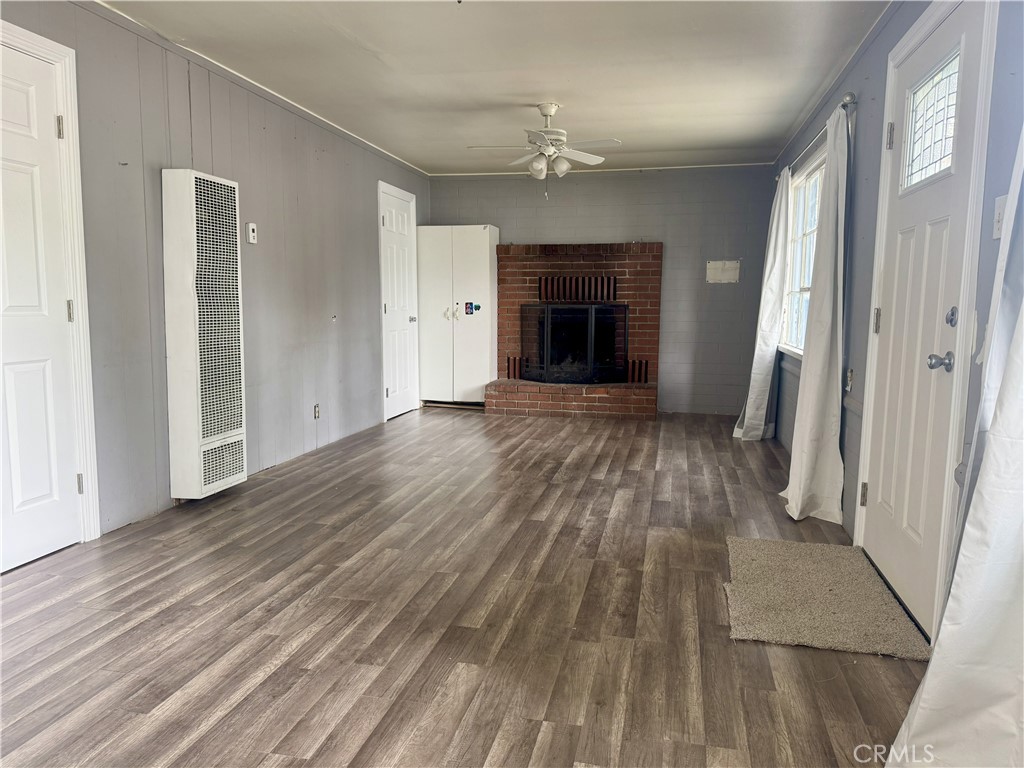 197 Western Drive Cedar Glen, CA 92321 - Photo 9 of 17 an empty room with wooden floor and fireplace