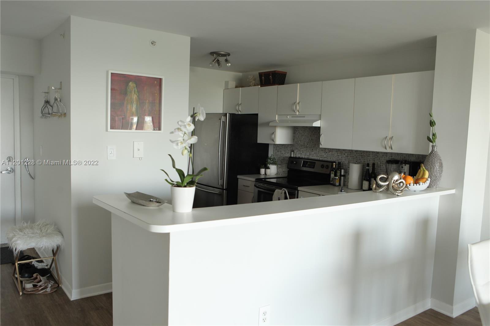 1401 Bay Road, Unit 507 Miami Beach, FL 33139 - Photo 4 of 10 a kitchen with stainless steel appliances a sink a stove a refrigerator a counter top space and cabinets