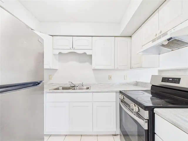 a kitchen with a sink a stove and cabinets