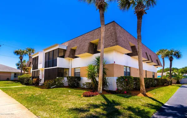 a view of a house with a yard and palm tree