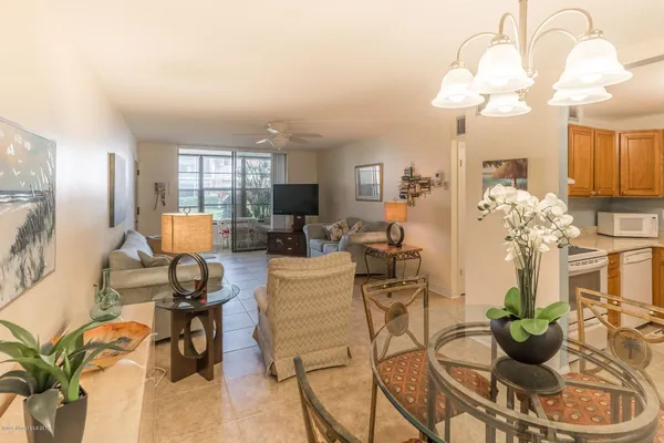 a living room with patio furniture and a chandelier