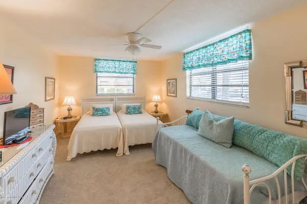 a spacious bedroom with two beds and a couch