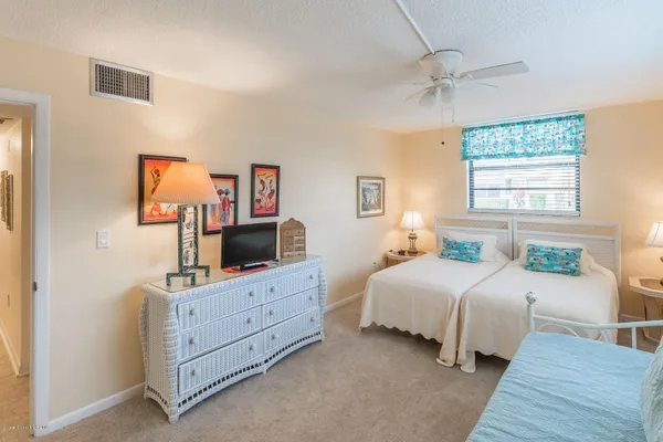 a bedroom with a bed and a flat tv screen on dresser