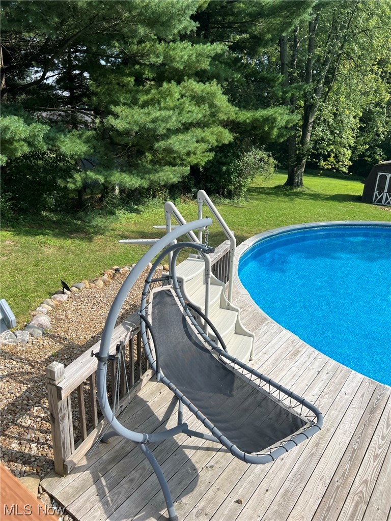 294 Lester Road New Franklin, OH 44319 - Photo 19 of 24 View of pool featuring a storage shed, wooden deck, and a yard