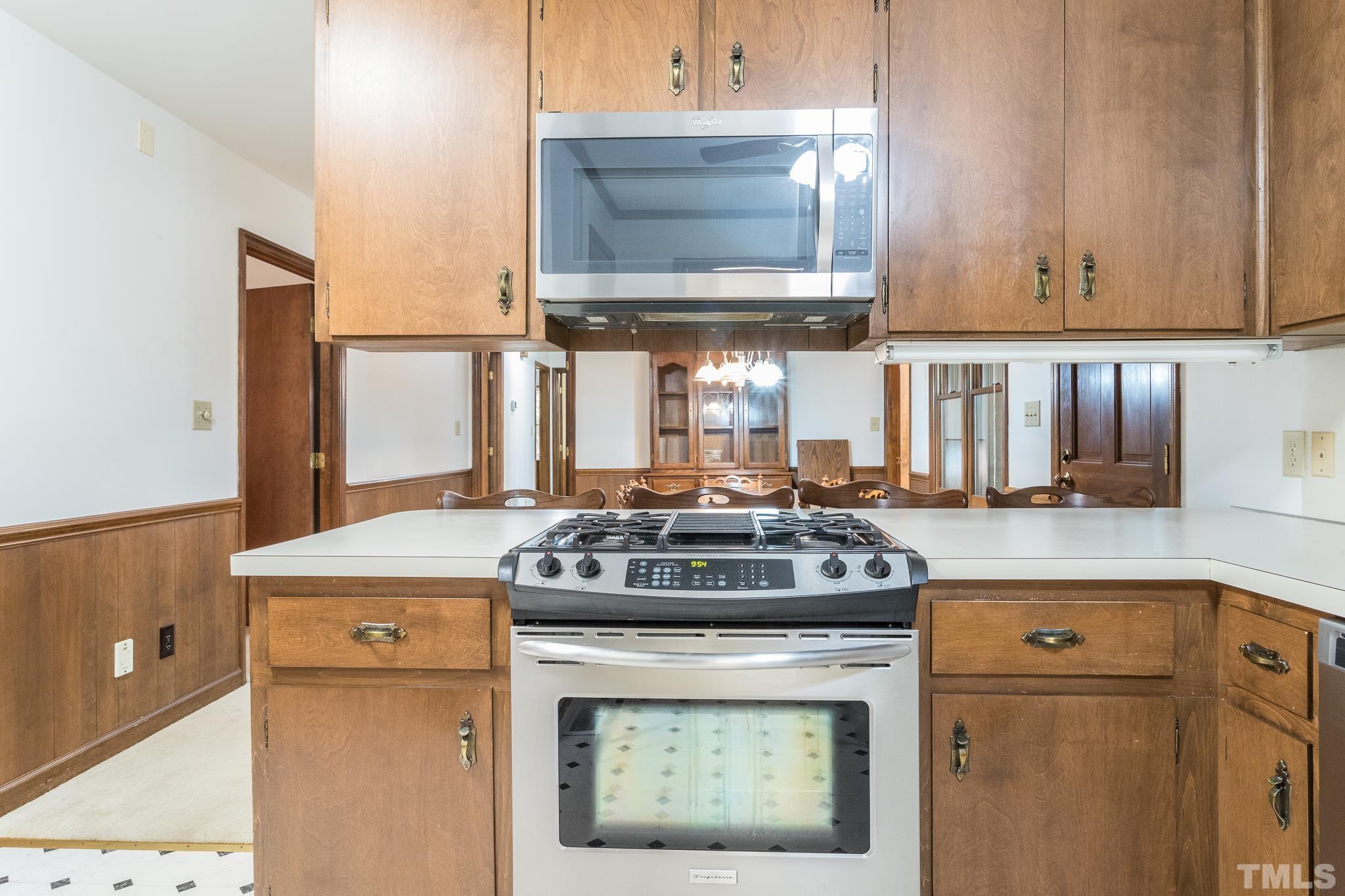 6304 Garrett Road Raleigh, NC 27606 - Photo 5 of 15 a kitchen with stainless steel appliances granite countertop a stove and a microwave