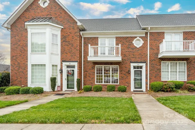 front view of a brick house with a yard