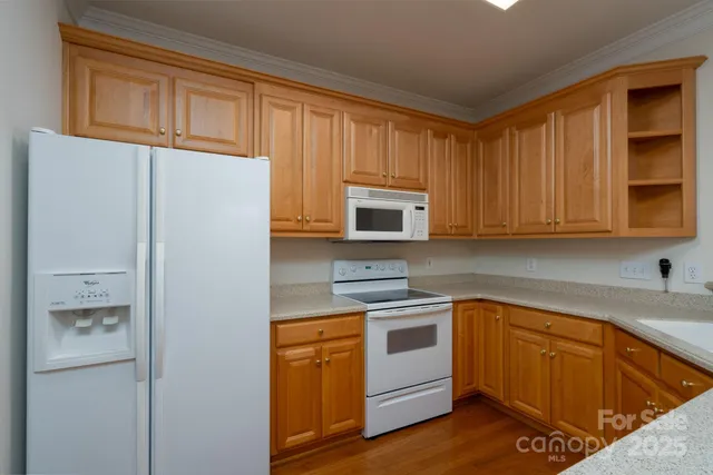 a kitchen with white cabinets and white appliances
