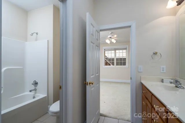 a bathroom with a bathtub shower sink vanity and toilet