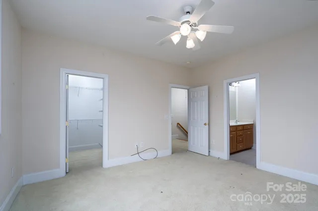 an empty room with closet and a ceiling fan