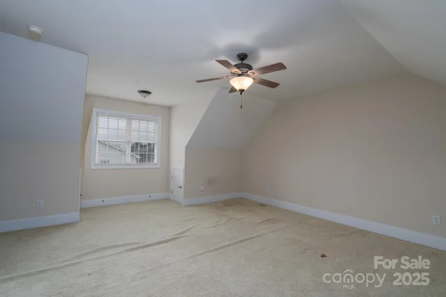 an empty room with a window and a ceiling fan
