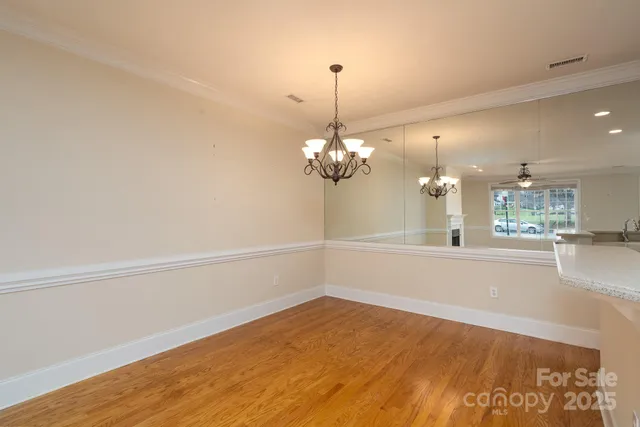 a view of a room with wooden floor and chandelier