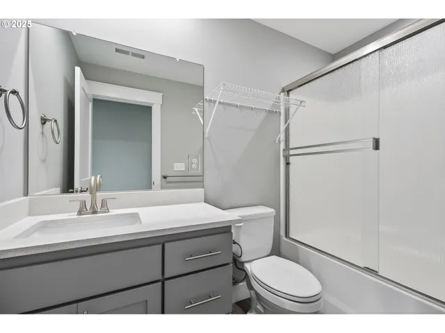 a bathroom with a sink toilet a mirror and shower