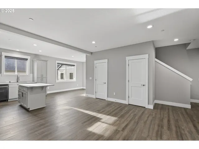 a view of a big room with wooden floor and windows