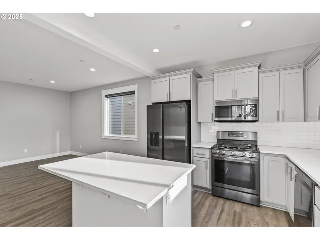 a kitchen with a refrigerator a stove a sink and a center island