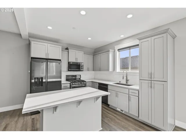 a kitchen with stainless steel appliances a sink stove and refrigerator