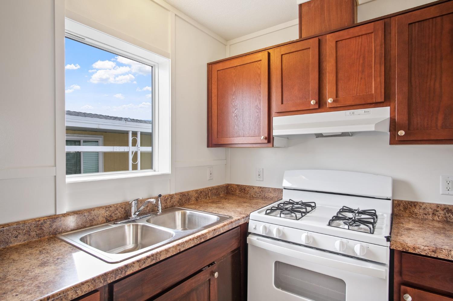 1400 Meredith Avenue, Unit 81 Gustine, CA 95322 - Photo 21 of 29 a kitchen with stainless steel appliances granite countertop a sink stove refrigerator and cabinets